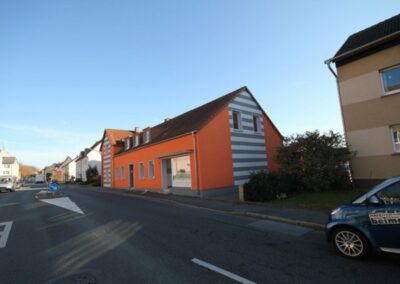 Haus mit orangener Farbe und weiß-grauen Streifen Farbe an zwei Stellen