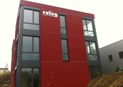 Hausfassade der Firma roteg. Die Fassadenfarbe ist rot und grau