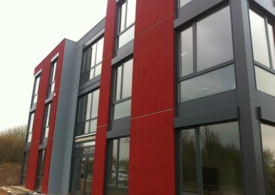 Hausfassade der Firma roteg. Die Fassadenfarbe ist rot und grau