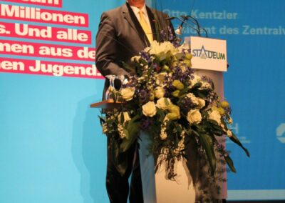 Mann hält auf einer Bühne einen Vortrag