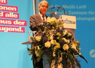Mann hält auf einer Bühne einen Vortrag